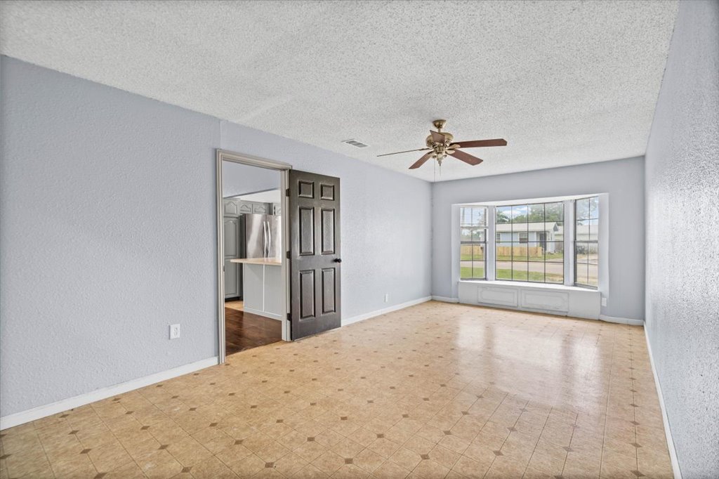 650 West Austin Street Luling, TX 78648 - Photo 8 of 18 A living area with patterned flooring and a wide bay window invites natural light and comfortable living.