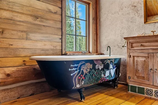a bathroom with a granite countertop sink a mirror and bathtub
