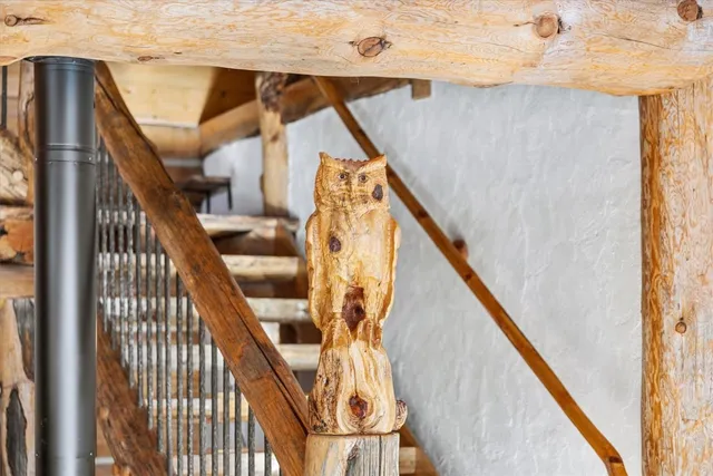 a view of an empty room with wooden floor and a bathroom