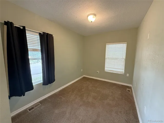 an empty room with windows and closet