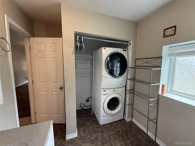 a view of a livingroom with a chandelier fan and windows
