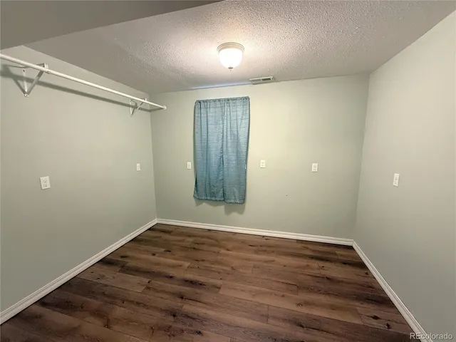 an empty room with wooden floor and mirror