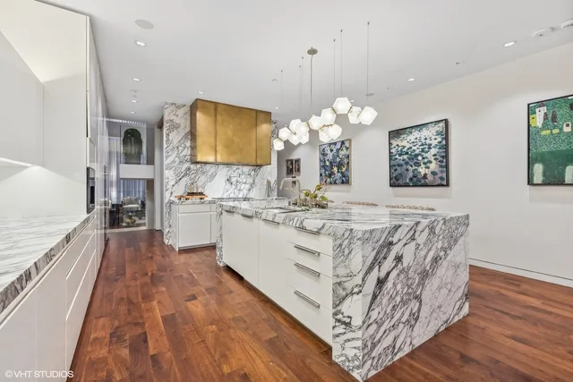 a kitchen with stainless steel appliances kitchen island granite countertop a refrigerator and a stove top oven