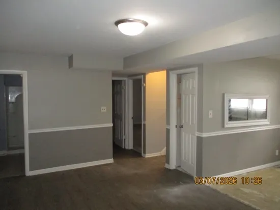 an empty room with windows and closet