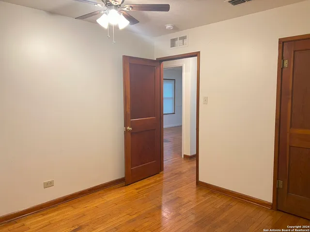 an empty room with a wooden floor and windows