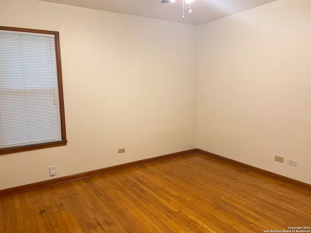 an empty room with wooden floor and a bathroom