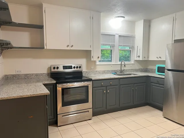 a kitchen with a sink stove and cabinets