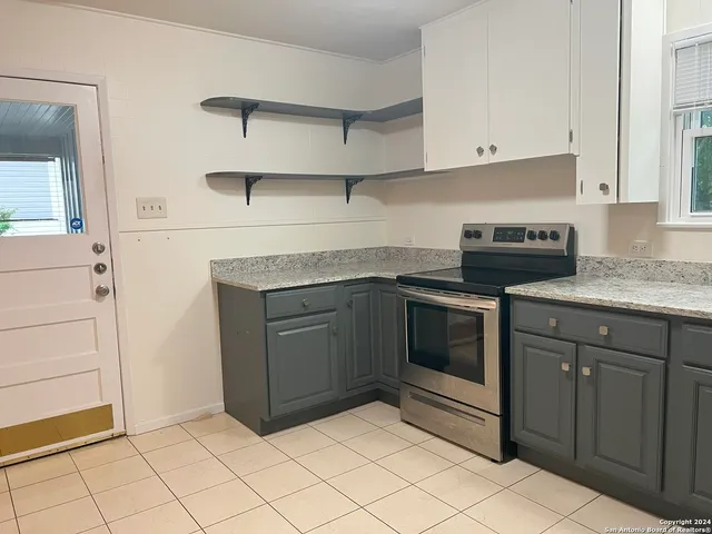 a kitchen with granite countertop white cabinets and white appliances