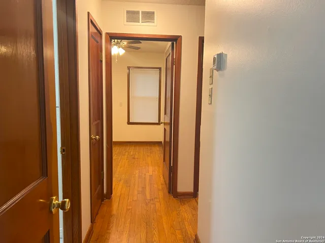 a view of a hallway with wooden floor