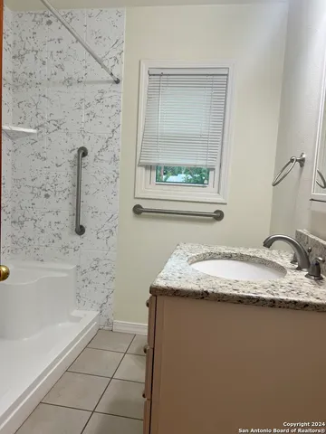 a bathroom with a granite countertop sink a toilet and bathtub