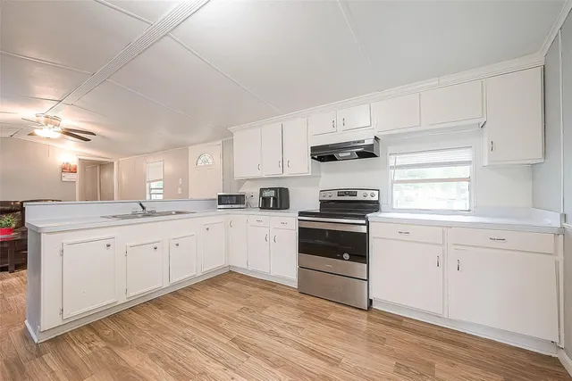 a kitchen with granite countertop white cabinets and white appliances