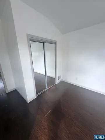 an empty room with wooden floor and entrance