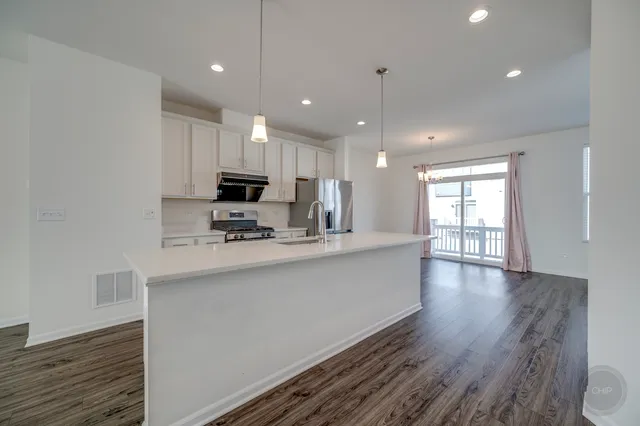a kitchen with stainless steel appliances granite countertop a sink stove and refrigerator