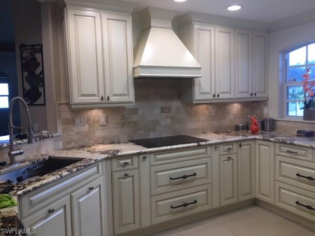 a kitchen with granite countertop a sink stove and cabinets