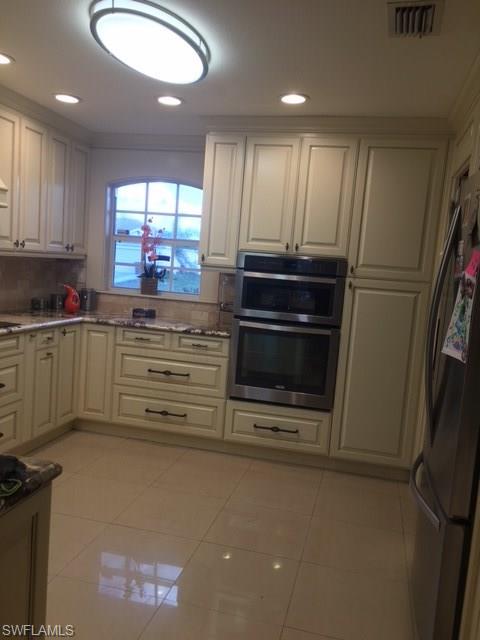 3906 14th Street Southwest Lehigh Acres, FL 33976 - Photo 21 of 25 a kitchen with stainless steel appliances a refrigerator and a stove top oven