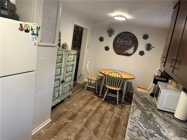 a view of a kitchen with fridge and wooden floor