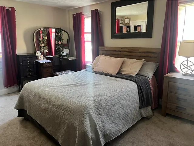 a bedroom with a bed and a mirror on dresser