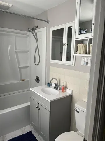 a bathroom with a sink toilet vanity and tub