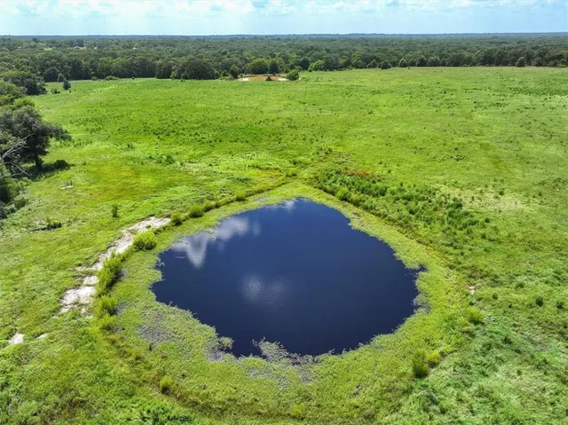 a view of a lake in a green field