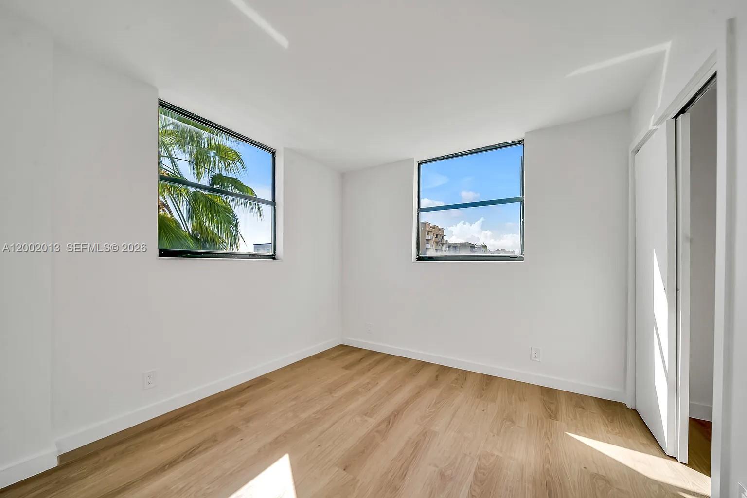 501 Southwest 1st Street, Unit 502 Miami, FL 33130 - Photo 11 of 24 a view of an empty room with wooden floor and a window