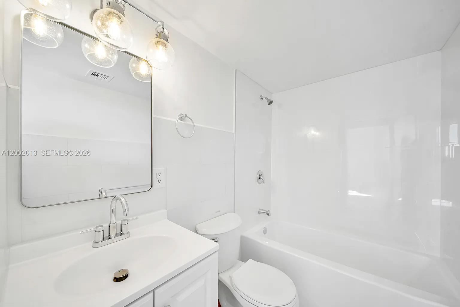 501 Southwest 1st Street, Unit 502 Miami, FL 33130 - Photo 13 of 24 a bathroom with a bathtub shower sink vanity and toilet