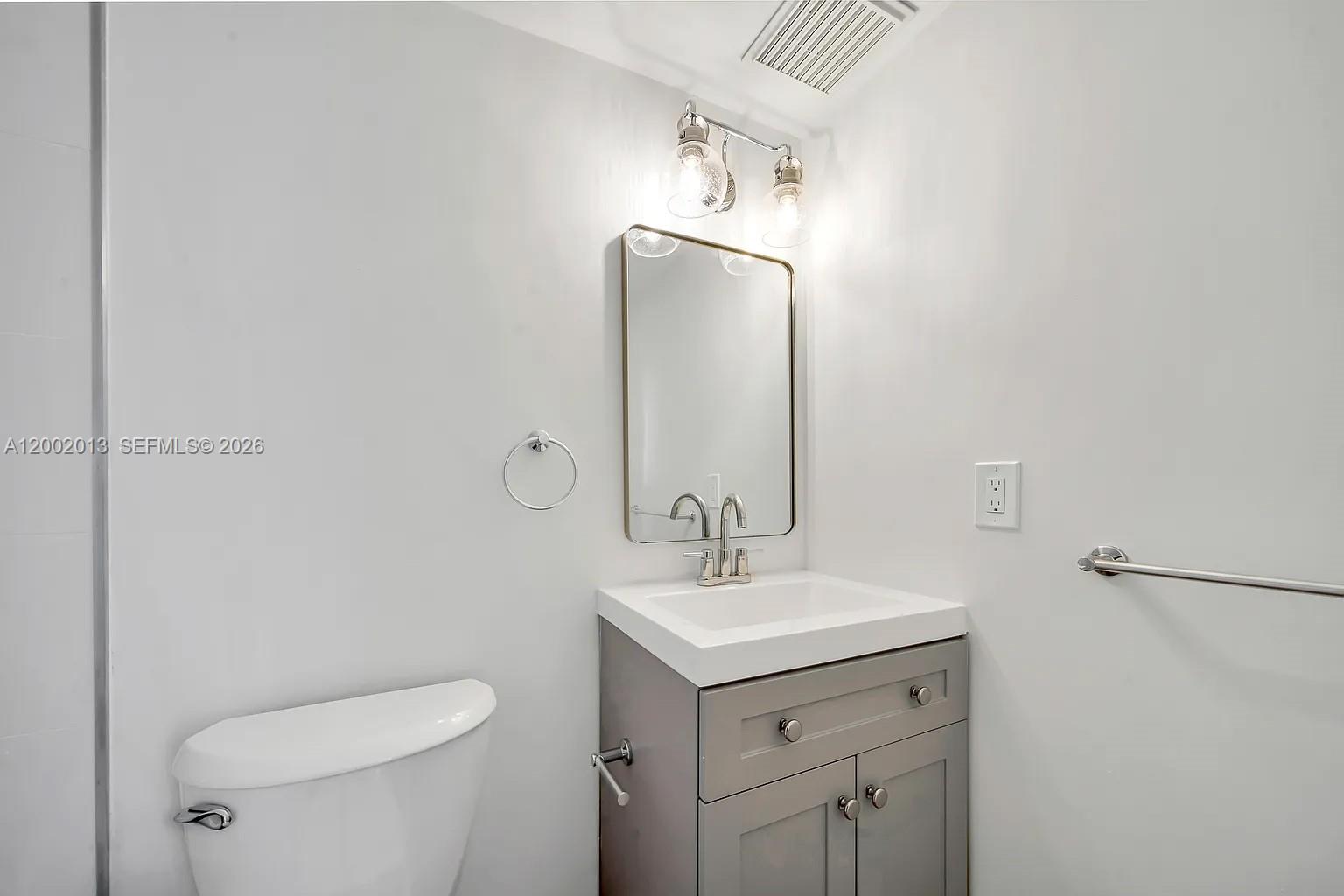 501 Southwest 1st Street, Unit 502 Miami, FL 33130 - Photo 19 of 24 a bathroom with a toilet a sink a mirror and vanity