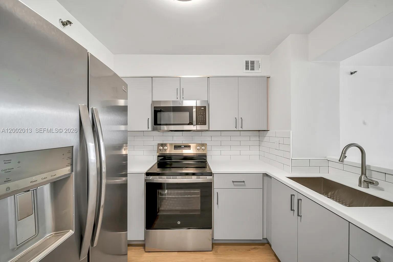 501 Southwest 1st Street, Unit 502 Miami, FL 33130 - Photo 8 of 24 a kitchen with a sink appliances and cabinets