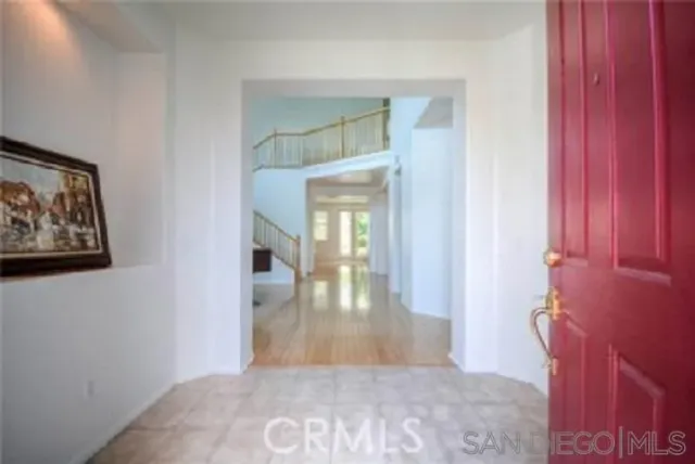 a view of a hallway with wooden floor and a living room