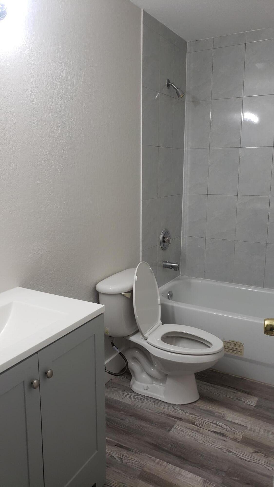 14040 Northeast 2nd Avenue Miami, FL 33161 - Photo 11 of 16 a white toilet sitting next to a bathroom sink and vanity