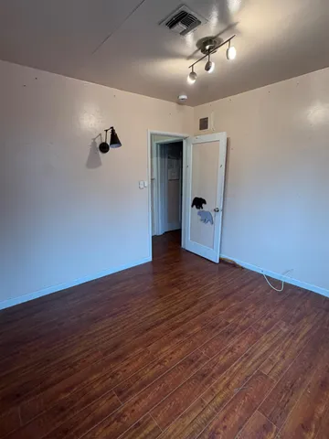 a view of empty room with wooden floor