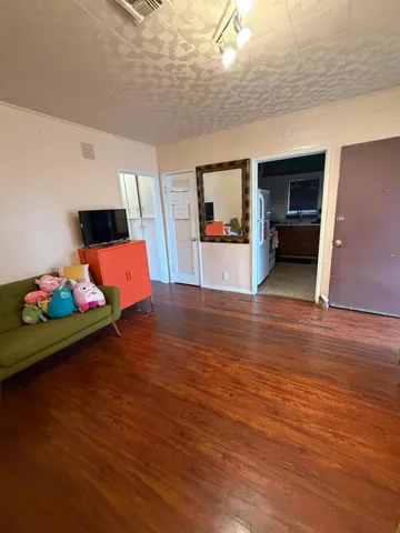 a view of a room with wooden floor and furniture