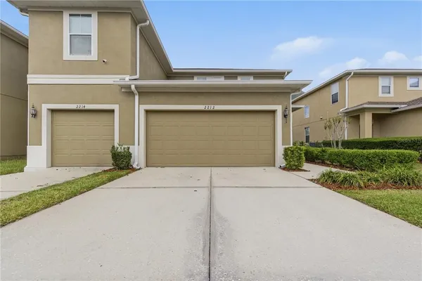 a front view of a house with a yard and garage