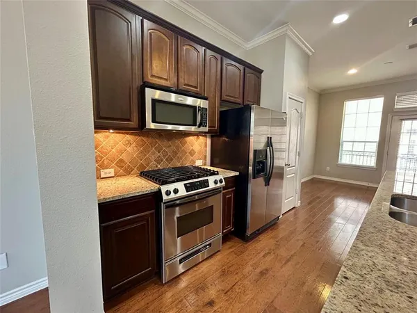 a kitchen with stainless steel appliances granite countertop a stove a microwave and a refrigerator