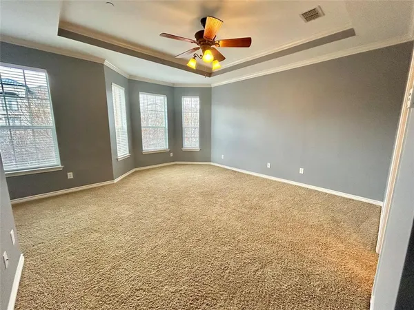 a view of an empty room and window and chandelier fan