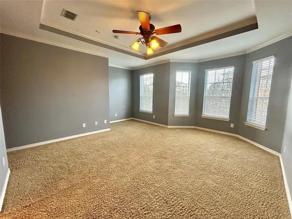 a view of an empty room with window and a kitchen