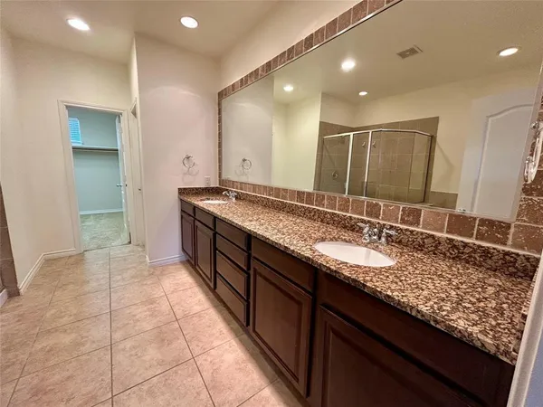 a bathroom with a granite countertop sink a mirror and a shower