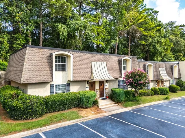 a front view of a house with a yard and trees