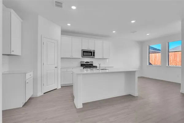 a kitchen with stainless steel appliances granite countertop a stove a sink and a refrigerator