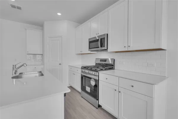 a kitchen with white cabinets and white appliances