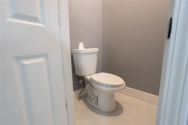 a white toilet sitting next to a white cabinet