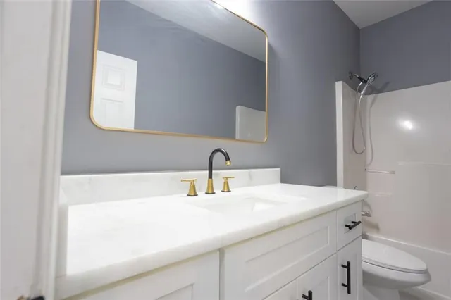 a bathroom with a sink a toilet and a mirror