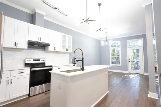 a kitchen with a sink and wooden floor