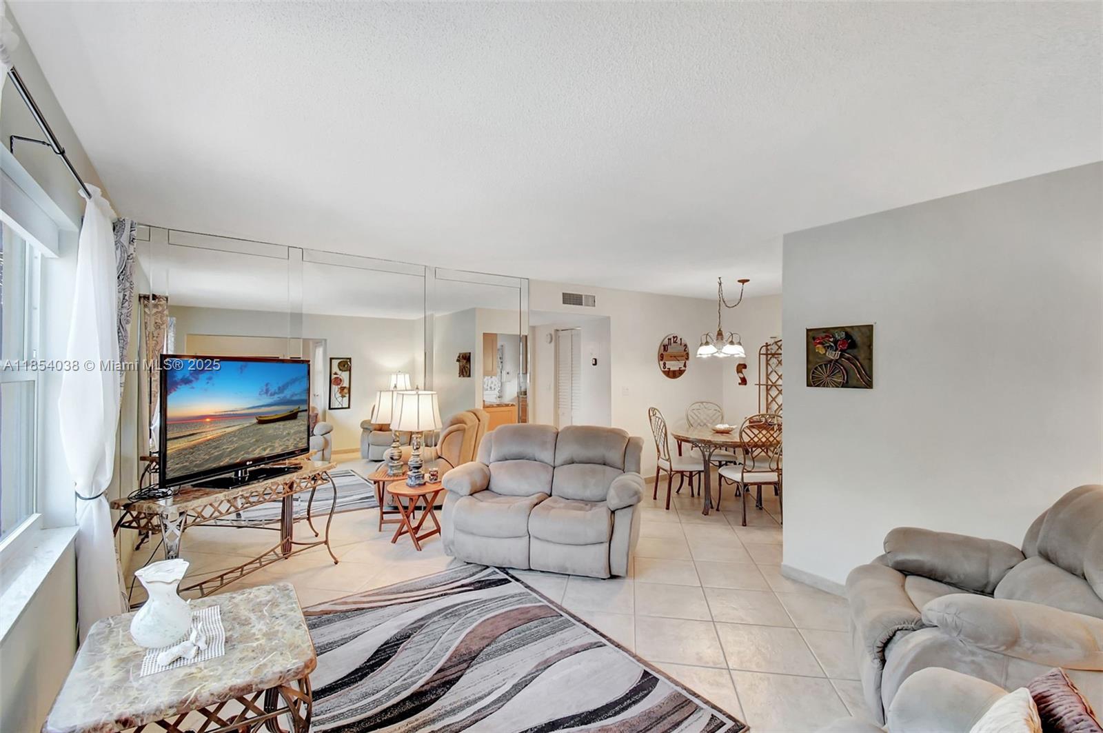 415 Northeast 2nd Street, Unit 201 Hallandale Beach, FL 33009 - Photo 11 of 34 a living room with furniture and a flat screen tv
