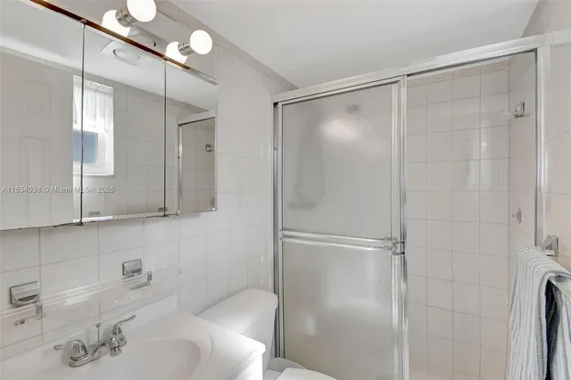 a bathroom with a shower sink vanity and toilet