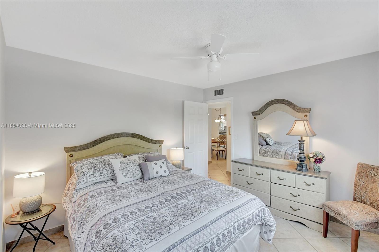 415 Northeast 2nd Street, Unit 201 Hallandale Beach, FL 33009 - Photo 23 of 34 a bedroom with a bed a chandelier and dresser