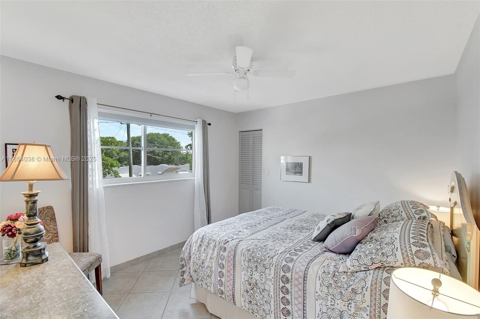 415 Northeast 2nd Street, Unit 201 Hallandale Beach, FL 33009 - Photo 24 of 34 a bedroom with a bed and a lamp with window
