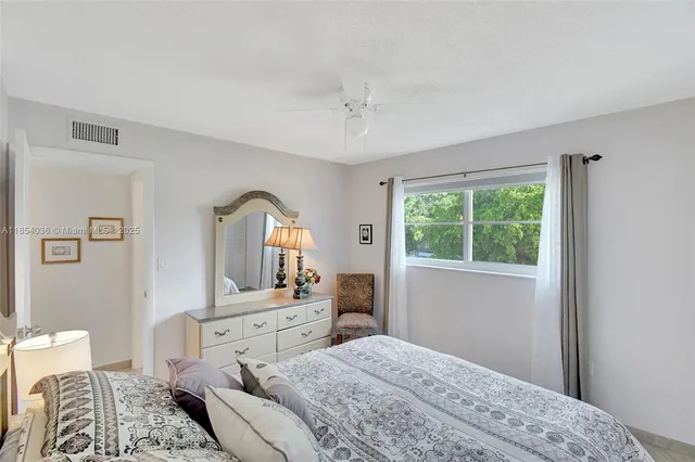 a bedroom with a bed and a dresser next to a window