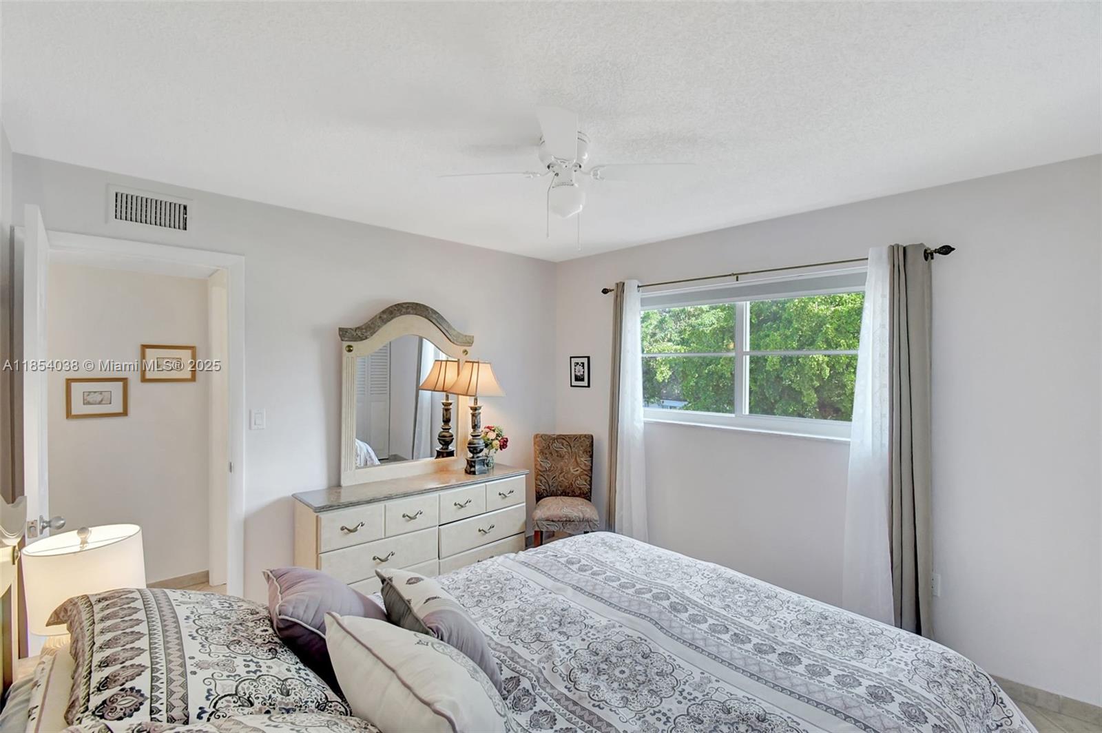 415 Northeast 2nd Street, Unit 201 Hallandale Beach, FL 33009 - Photo 25 of 34 a bedroom with a bed and a dresser next to a window