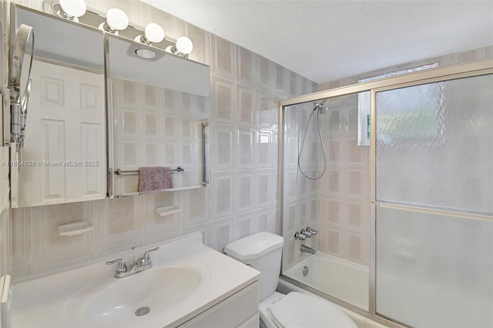 415 Northeast 2nd Street, Unit 201 Hallandale Beach, FL 33009 - Photo 26 of 34 a bathroom with a sink toilet and shower