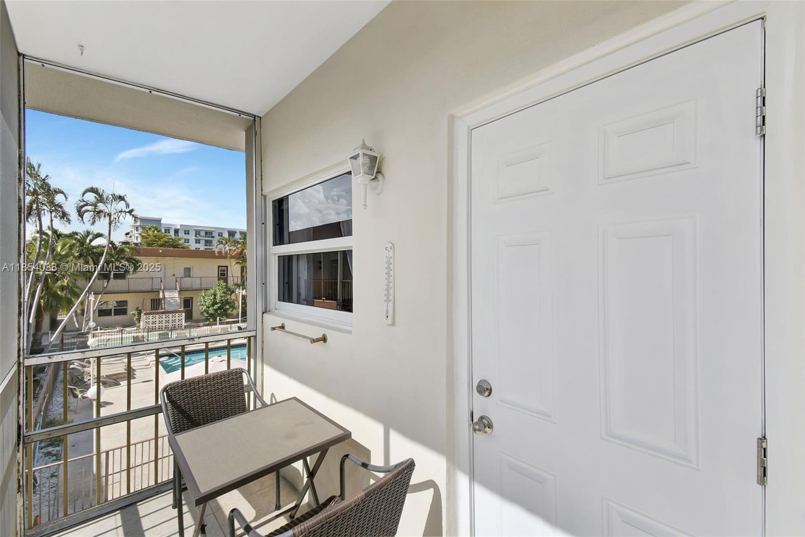 415 Northeast 2nd Street, Unit 201 Hallandale Beach, FL 33009 - Photo 28 of 34 a living room with furniture a flat screen tv and a floor to ceiling window